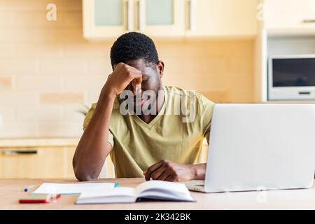 brasilianischer Mann verzweifelt Rechnungen für Zahlungen in der Küche zu überprüfen Stockfoto