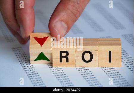 Return on Investment Text auf Holzblöcken mit Hand drehen Holzblock mit auf und ab Symbol. Investitionskonzept. Stockfoto