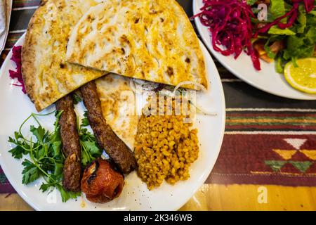 Urfa Kebab, traditionelle türkische Küche mit Kebab-Fleisch, Gemüse auf dem Teller in Sanliurfa, Türkei Stockfoto