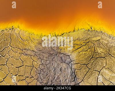 Gesprungene Erde am Ufer des Rio Tinto (Red River) mit seinem tiefen rötlichen Farbton aufgrund oxidierter Eisenminerale im Wasser, Luftaufnahme, Drohnenschuss Stockfoto