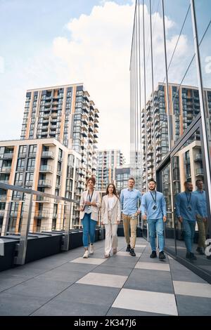 Ein multiethnisches Team von Firmenmitarbeitern, die während der Mittagspause spazieren gehen Stockfoto