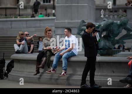 Touristen saßen am Trafalgar Square, London, am 26. 2013. Juni, Stockfoto