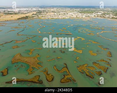 Netzwerk von Kanälen und Bächen bei Ebbe, im Sumpfgebiet der Bahia de Cádiz, in der Ferne die Stadt Chiclana de la Frontera, Luftlinie Stockfoto