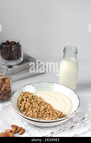 Müsli und Joghurt in einer Keramikschale, Hafer und Nüsse Parfait, geröstetes Honiggranola mit Joghurt in einer Keramikschale Stockfoto