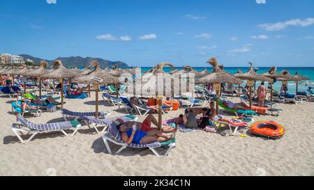 Lebhafter Strand Playa de Sant Llorenc mit Sonnenschirmen, Cala Millor, Mallorca, Spanien Stockfoto