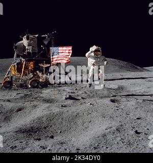 Mondoberfläche. 23. September 2022. DATEI: Astronaut John W. Young, Kommandant der Mondlandemission Apollo 16, springt von der Mondoberfläche, als er während des ersten Apollo 16-Spacewalks die US-Flagge am Landeplatz Descartes begrüßt. Astronaut Charles M. Duke Jr., Mondmodulpilot, nahm dieses Bild am 21. April 1972 auf. Die Mondlandefähre Orion befindet sich auf der linken Seite und daneben befindet sich das Lunar Roving Vehicle. Hinter Young, im Schatten von Orion, steht die Ultraviolett-Kamera/Spektrograph Far. Young und Duke führten mit dem Lunar Ro drei Oberflächenexkursionen mit einer Gesamtdauer von mehr als 20 Stunden durch Stockfoto