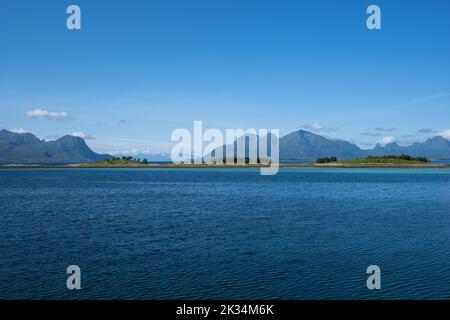 Wunderschöne Landschaften in Norwegen. Nordland. Wunderschöne Landschaft einer Küste vom Strand von Mortenstranda. Geriffeltes Meer an einem sonnigen Sommertag.Weiße Wolken und ein Stockfoto