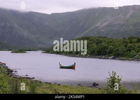 Wunderschöne Landschaften in Norwegen. Nordland. Schöne Landschaft eines Tales mit einem malerischen Boot im Storvatnet See. Gewelltes Wasser in einem wolkigen Summ Stockfoto