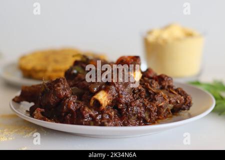 Hammelbraten serviert mit Makki KI roti oder Maisroti. Würziger Hammelbraten im Kerala-Stil, serviert mit indischem, ungesäuertem Fladenbrot aus C. Stockfoto