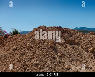 Erdhaufen mit blauem Himmel. Getrocknete Erde. Stockfoto