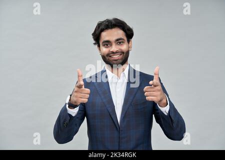 Lächelnder indischer arabischer Geschäftsmann, der isoliert auf beige auf Sie zeigt. Stockfoto