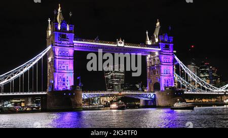 London, Großbritannien, 24.. September 2022. Die Flottille erreicht die Tower Bridge, die als Tribut an die Königin in Purpur beleuchtet ist. Reflections, eine nächtliche Flottille auf der Themse in London, markiert den Tod Ihrer Majestät der Königin und den Beitritt von König Karl III. Die beleuchtete Flottille, die Teil der Totally Thames ist, fährt von der Chelsea Bridge zur Tower Bridge, wobei das Herzstück der Queen's Row Barge Gloriana ist. Kredit: Imageplotter/Alamy Live Nachrichten Stockfoto