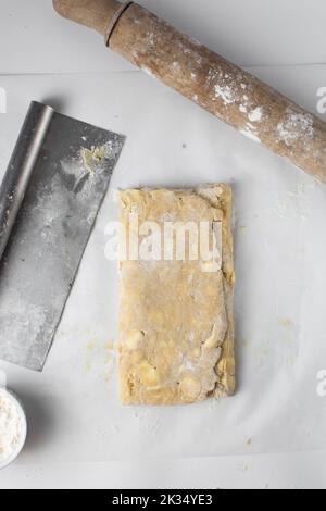 dänischer Teig, der laminiert wird, Teig mit Stücken kalter Butter, Verfahren des Laminierteigs, Teig aus Briefpapier Stockfoto