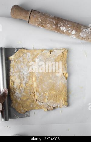 dänischer Teig, der laminiert wird, Teig mit Stücken kalter Butter, Verfahren des Laminierteigs, Teig aus Briefpapier Stockfoto