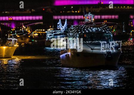 London, Großbritannien. 24. September 2022. Reflections, Totally Thames Festival - eine Nachtflottille mit Booten auf der Themse. Ursprünglich als Teil des Platin-Jubiläums geplant, wird die Flottille den Tod Ihrer Majestät und den Beitritt von König Karl III. Markieren Etwa 150 Boote, darunter die Rowbarge Gloriana der Queen, die mit Lichterketten und anderen Lichtern beleuchtet ist, fahren von Chelsea zur Tower Bridge, die violett beleuchtet wird. Kredit: Guy Bell/Alamy Live Nachrichten Stockfoto