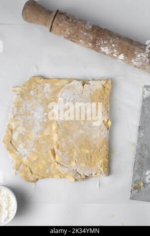 dänischer Teig, der laminiert wird, Teig mit Stücken kalter Butter, Verfahren des Laminierteigs, Teig aus Briefpapier Stockfoto