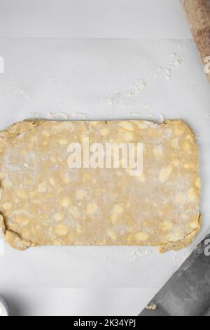 dänischer Teig, der laminiert wird, Teig mit Stücken kalter Butter, Verfahren des Laminierteigs, Teig aus Briefpapier Stockfoto