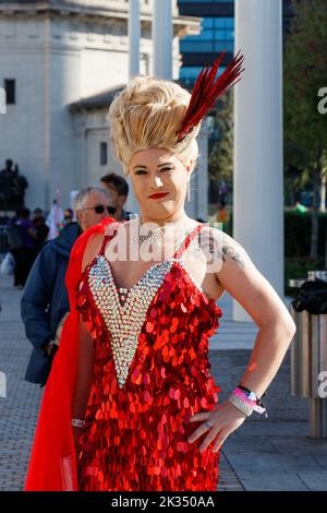 Blonde Trans-Frau in Drag trägt rotes funkelndes Kleid bei der Gay Pride Parade 2022 im Zentrum von Birmingham, großbritannien, 24. 2022. september Stockfoto