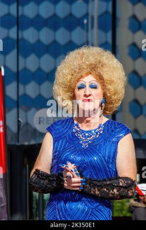 Trans-Frau in Drag trägt blonde Perücke und funkelndes blaues Kleid bei der Gay Pride Parade 2022 im zentrum von birmingham, großbritannien, 24.. september Stockfoto