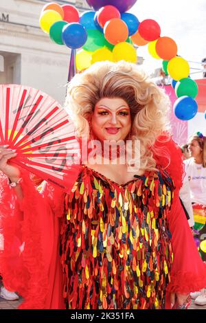Blonde Trans-Frau in Drag in rot funkelndem Kleid mit Fan bei Gay Pride Parade Protest 2022 im Zentrum von Birmingham uk september 24. 2022 Stockfoto
