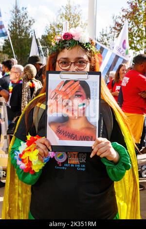 asiatische Frau mit Schild gegen iran Tod mahsa amini Gay Pride Parade Protest 2022 in Birmingham Stadtzentrum großbritannien 24.. september Stockfoto