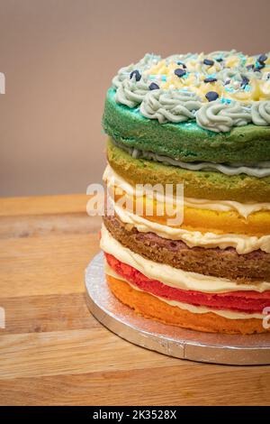Eine vertikale Aufnahme eines hausgemachten Regenbogenkuchen auf einem Tisch Stockfoto