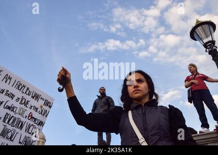 London, Großbritannien. 24. September 2022. Eine Frau hält eine Haarsträhne, die sie aus Protest abgeschnitten hat. Tausende Iraner und andere Demonstranten versammelten sich auf dem Trafalgar Square als Reaktion auf den Tod von Mahsa Amini, der in Polizeigewahrsam im Iran starb, nachdem er festgenommen wurde, weil er angeblich in der Öffentlichkeit kein Kopftuch (Hijab) „ordnungsgemäß“ trug. Kredit: Vuk Valcic/Alamy Live Nachrichten Stockfoto