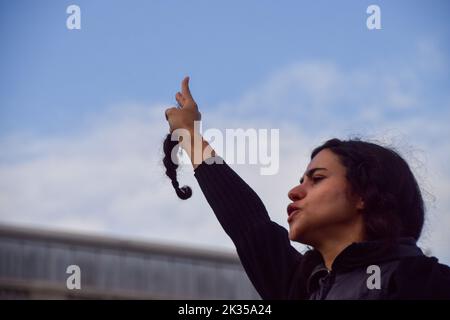 London, Großbritannien. 24. September 2022. Eine Frau hält eine Haarsträhne, die sie aus Protest abgeschnitten hat. Tausende Iraner und andere Demonstranten versammelten sich auf dem Trafalgar Square als Reaktion auf den Tod von Mahsa Amini, der in Polizeigewahrsam im Iran starb, nachdem er festgenommen wurde, weil er angeblich in der Öffentlichkeit kein Kopftuch (Hijab) „ordnungsgemäß“ trug. Kredit: Vuk Valcic/Alamy Live Nachrichten Stockfoto