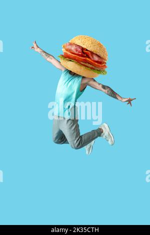 Springender tätowierte Mann mit leckeren Burger anstelle seines Kopfes auf hellblauem Hintergrund Stockfoto
