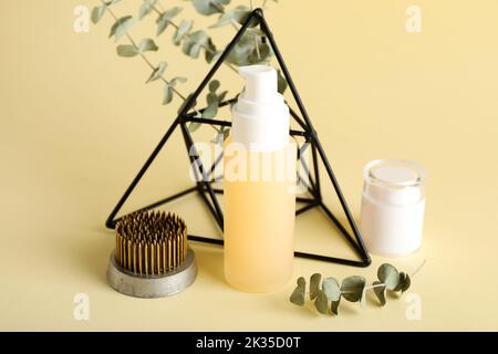 Kosmetikprodukte mit kenzan, Eukalyptuszweigen und Dekor auf beigem Hintergrund Stockfoto