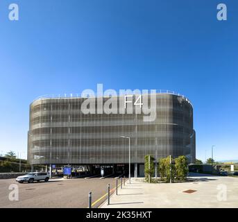 Basel, Schweiz - 22. Sep 2022: Modernes Gebäude mit F4 Parkplätzen am EuroAirport - Basel Mulhouse Freiburg Airport mit großem F4 Schild an der Fassade mit Jeep-Auto Stockfoto