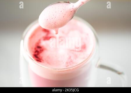 Doppelwandige Glas-Thermobecher mit Rote Bete Latte, Pink Latte ist eine modische und relevante Alternative zu Kaffee. Koffein zugunsten eines HE aufgeben Stockfoto