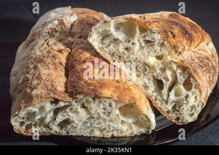 Handgemachtes Brot mit natürlicher Gärung auf einer schwarzen Schale. Stockfoto