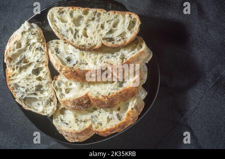 Handgemachtes Brot mit natürlicher Gärung auf einer schwarzen Schale. Stockfoto