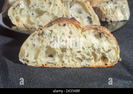 Handgemachtes Brot mit natürlicher Gärung auf einer schwarzen Schale. Stockfoto