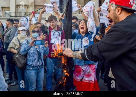 London, Großbritannien. 24. September 2022. Demonstranten verbrennen während der Demonstration einen Hijab. Tausende Iraner und andere Demonstranten versammelten sich auf dem Trafalgar Square als Reaktion auf den Tod von Mahsa Amini, der in Polizeigewahrsam im Iran starb, nachdem er festgenommen wurde, weil er angeblich in der Öffentlichkeit kein Kopftuch (Hijab) „ordnungsgemäß“ trug. Kredit: SOPA Images Limited/Alamy Live Nachrichten Stockfoto