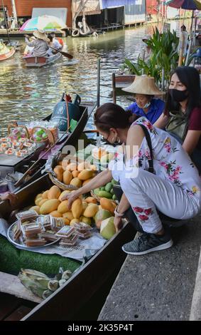 Ratchaburi, Thailand April 10, 2022 - Damnoen Saduak schwimmende Marktverkäufer in Thailand verkaufen Obst, Gemüse und Waren von ihrem Boot aus. Stockfoto