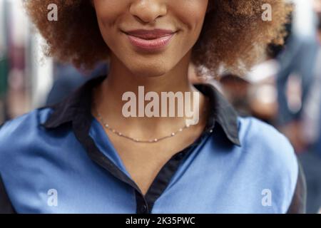 Nahaufnahme einer lächelnden afrikanischen Geschäftsfrau, die im modernen Büro steht Stockfoto
