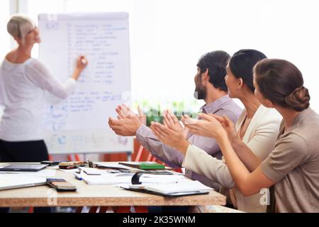 Zeigt ihnen die neuesten Ergebnisse. Eine Teamleiterin, die ihren Kollegen eine Präsentation macht. Stockfoto