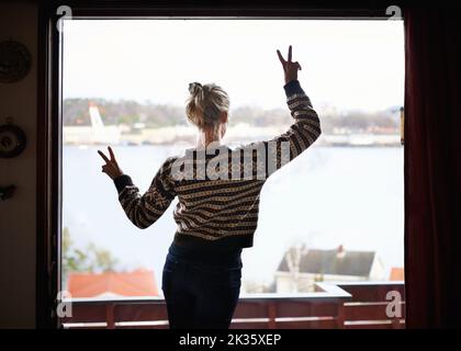 Die Aussicht genießen. Rückansicht einer Frau, die aus dem Fenster schaute. Stockfoto