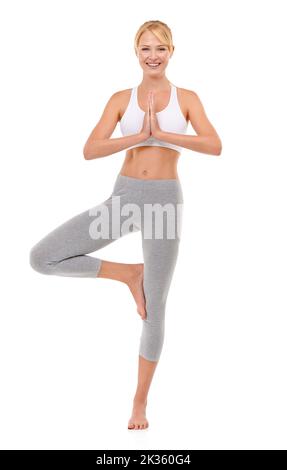 Für einen guten Körper UND Geist. Ganzkörperaufnahme einer attraktiven jungen Frau, die isoliert auf Weiß Yoga praktiziert. Stockfoto