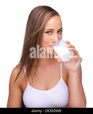 Es tut dem Körper gut. Eine schöne junge Frau, die ein Glas Milch trinkt. Stockfoto