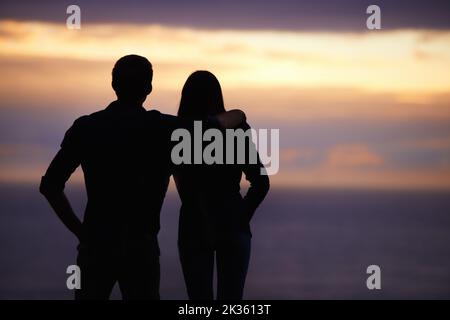 Bewundern Sie die Schönheit des Sonnenuntergangs - Seite an Seite. Zwei Personen mit Blick auf den Sonnenuntergang. Stockfoto