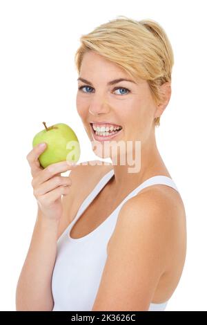 Sie muss sich an ihren Essplan halten, eine junge Frau, die einen Apfel hält. Stockfoto