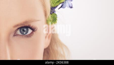 Nur ein Blick auf die wahre Schönheit. Porträt einer attraktiven jungen Frau mit schönen Blumen. Stockfoto