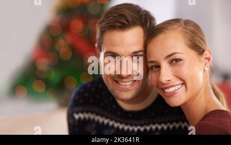Weihnachtspaar. Porträt eines glücklichen jungen Paares am Weihnachtstag. Stockfoto