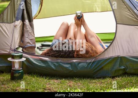 Erinnerungen an einen lustigen Campingausflug. Zwei junge Freunde, die sich während eines Campingausflugs fotografieren. Stockfoto