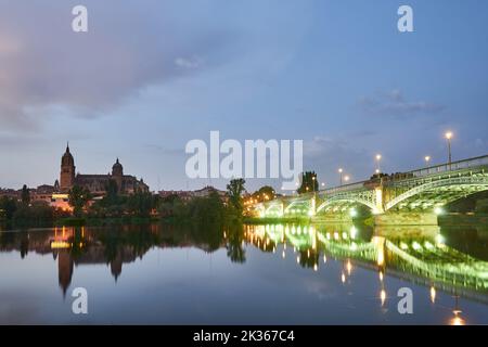 Die Kathedrale von Salamanca bei Nacht und die Enrique Esteban Brücke Blick vom Tormes Fluss, Salamanca Stadt, Spanien, Europa. Stockfoto