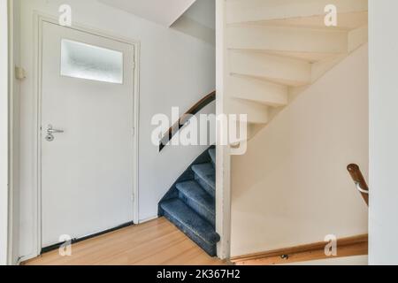 Weißer Flur mit Treppe führt in die zweite Etage eines modernen Luxusapartments mit minimalistischem Innendesign Stockfoto