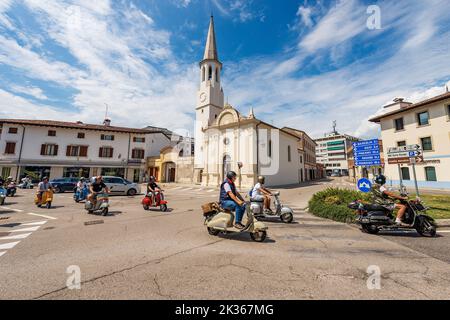 Kleine Kirche von San Rocco mit dem Glockenturm. Spilimbergo, Pordenone, Friaul-Julisch Venetien, Italien, Europa. Biker auf dem Roller Piaggio Vespa. Stockfoto